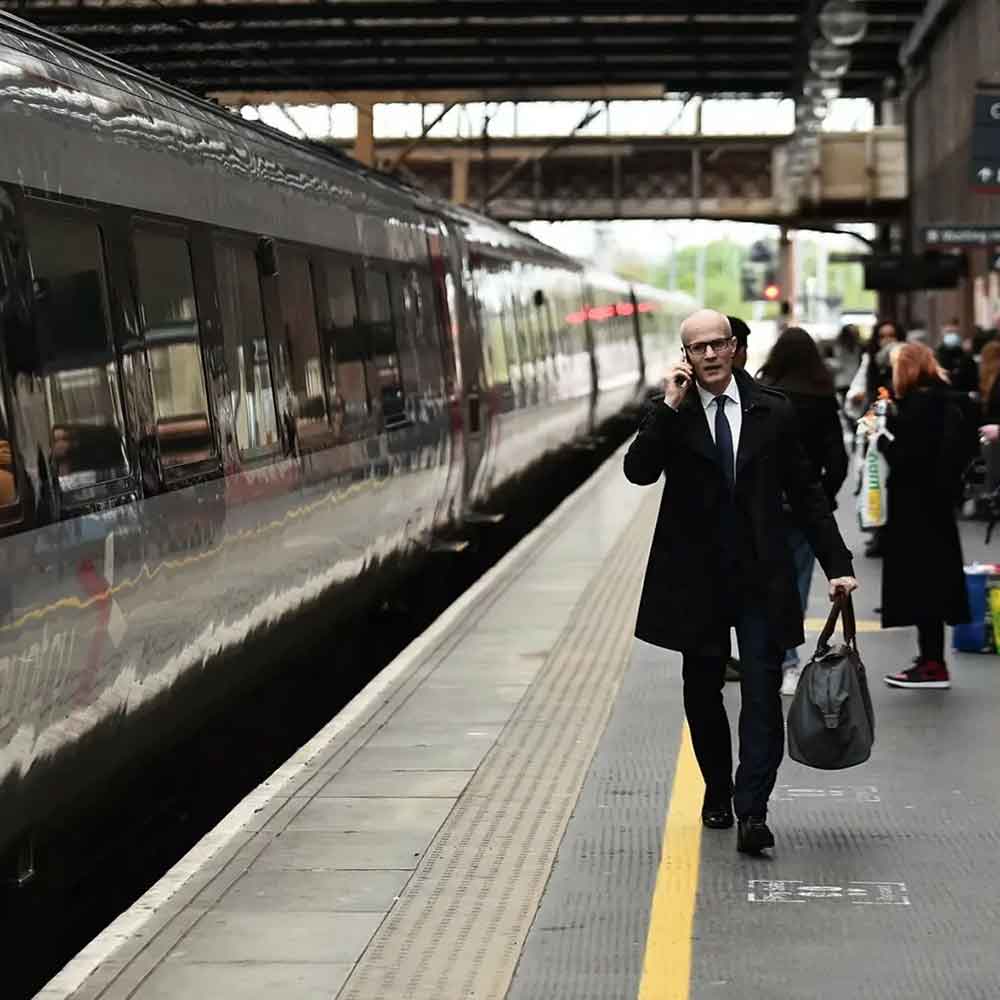 Business man on mobile phone at railway platform